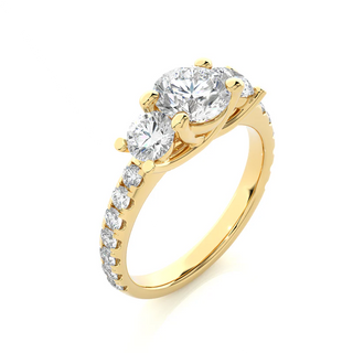 Angled view of 2.50 Ct Round Moissanite Trellis Prong Three Stone Engagement Ring Yellow Gold, showcasing the band and setting.​