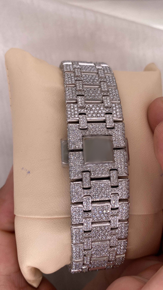 Close-up of iced-out moissanite watch bracelet with rectangular links, fully encrusted with pavé-set diamonds on a silver finish.