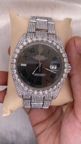 Front view Luxury iced out moissanite watch with silver band, black dial, Roman numerals, and sparkling stones on bezel and bracelet.