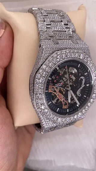 Side view of a cheap moissanite skeleton watch showing stone-studded case, crown, and part of the mechanical dial.