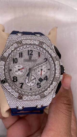 Side view of a men’s moissanite watch showing the detailed case, crown, and blue strap, held in hand for display.