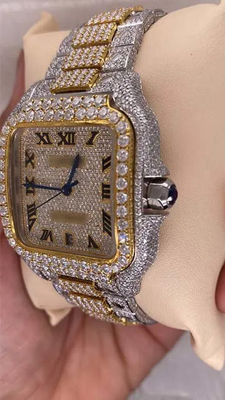Side view of a moissanite watch for men showing the iced bezel, crown, and two-tone metal band, held in hand.