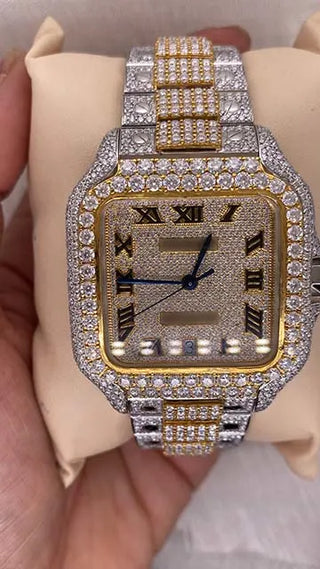 Front view of a moissanite watch for men featuring a fully iced dial, Roman numerals, and a two-tone metal band.