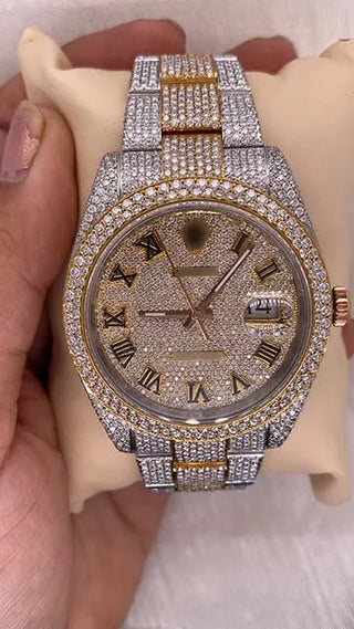 Front view of a moissanite watch for sale featuring a gold-tone Roman numeral dial, date window, and fully stone-studded case and strap.