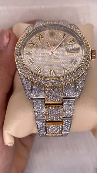 Side view of a moissanite watch with a gold-tone dial, stone-studded bezel and case, and detailed metal strap design.