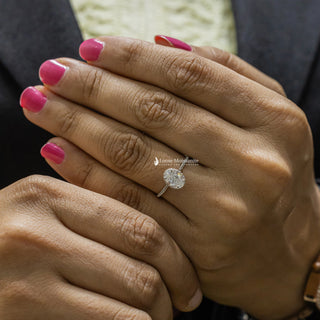 1 Carat Moissanite Oval Hidden Halo Engagement Ring​ with a delicate pavé band, worn on a hand with pink manicured nails for a stylish presentation.