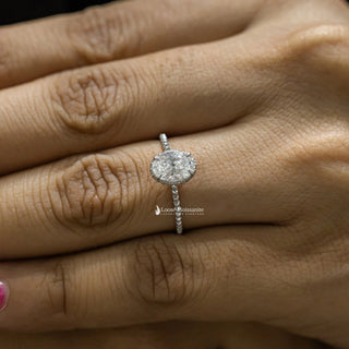 1 Carat Moissanite Oval Hidden Halo Engagement Ring​ with a diamond-accented band, worn on a hand with natural lighting.
