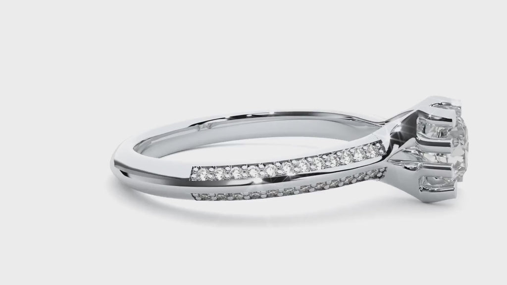 Video of a white gold solitaire engagement ring featuring a round brilliant moissanite in an 8-prong setting, shown on a hand.