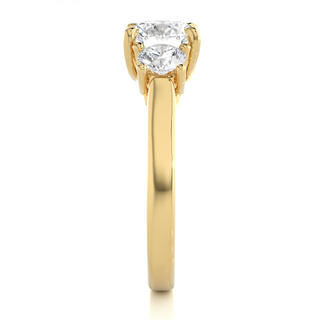 Side profile of 1.50 Ct Round Moissanite Three Stone Engagement Ring In Yellow Gold, highlighting the brilliant center moissanite stone., highlighting the prong setting.