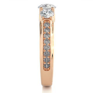 Side profile of 2 Ct Round Moissanite Three Stone Engagement Ring In Rose Gold, highlighting the brilliant center moissanite stone., highlighting the prong setting.