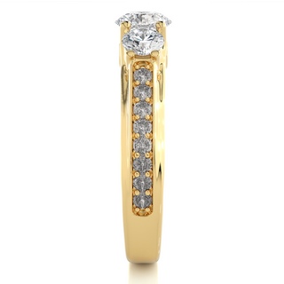 Side profile of 2 Ct Round Moissanite Three Stone Engagement Ring In Yellow Gold, highlighting the brilliant center moissanite stone, highlighting the prong setting.