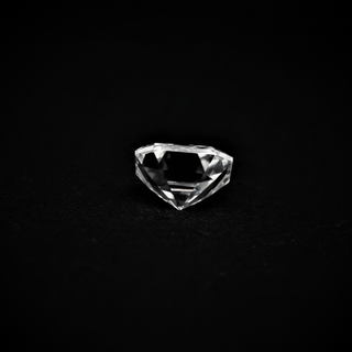 Back view of an Asscher cut Moissanite loose stone placed on a black surface.