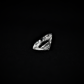 Side view of an Asscher cut Moissanite gemstone showcasing its step-cut facets and clarity against a dark background.