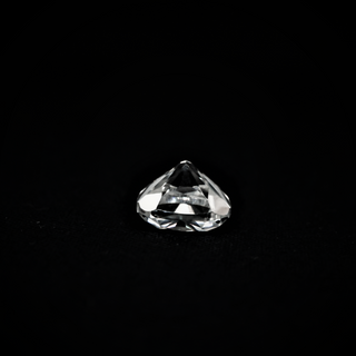 Back view of a cushion-cut moissanite resting on a black textured surface, highlighting its pavilion and faceted structure.