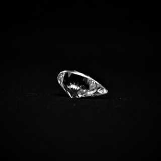 Side view of pear cut moissanite—teardrop shape with sharp facets that shine brightly from every angle.