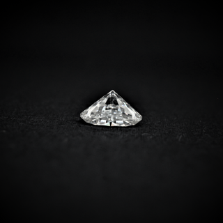 Back view of a loose round brilliant-cut moissanite gemstone displaying its faceted pavilion against a black background.