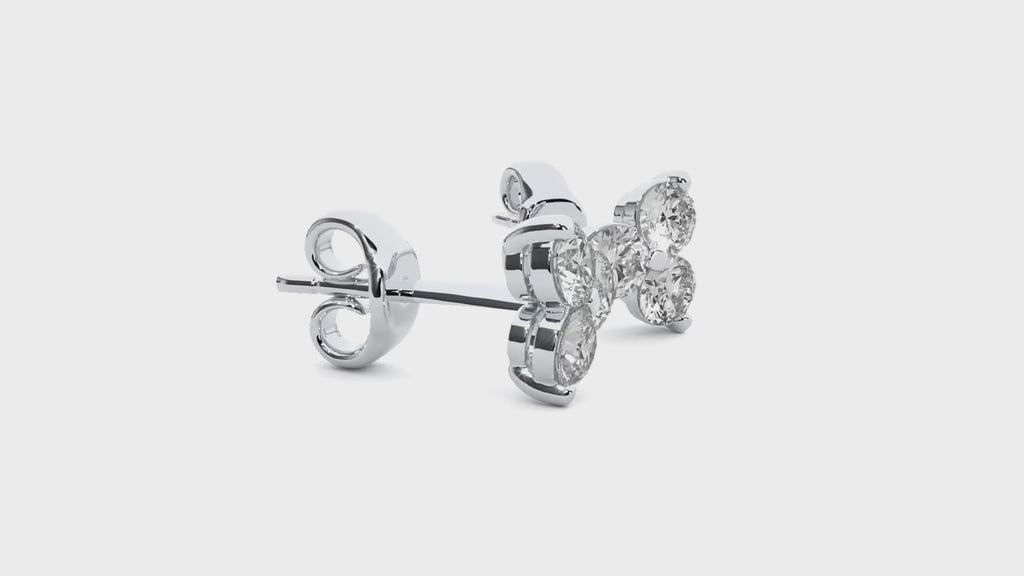Video showing white gold earrings with three round moissanite stones in a triangle shape, turning to show sparkle from all sides.