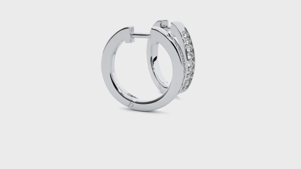 Video of white gold hoop earrings with round moissanite stones in channel setting, shown sparkling from multiple angles.